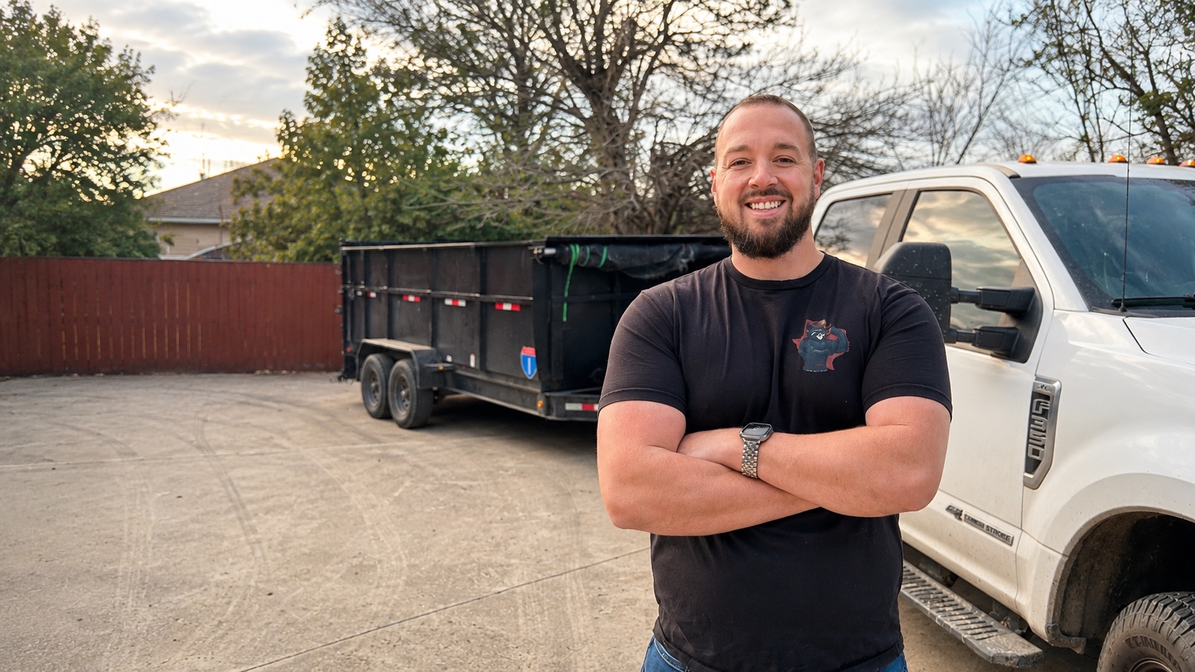 Gage, owner of Dumpster Daddies Junk Removal, standing with truck and trailer in Leander, TX